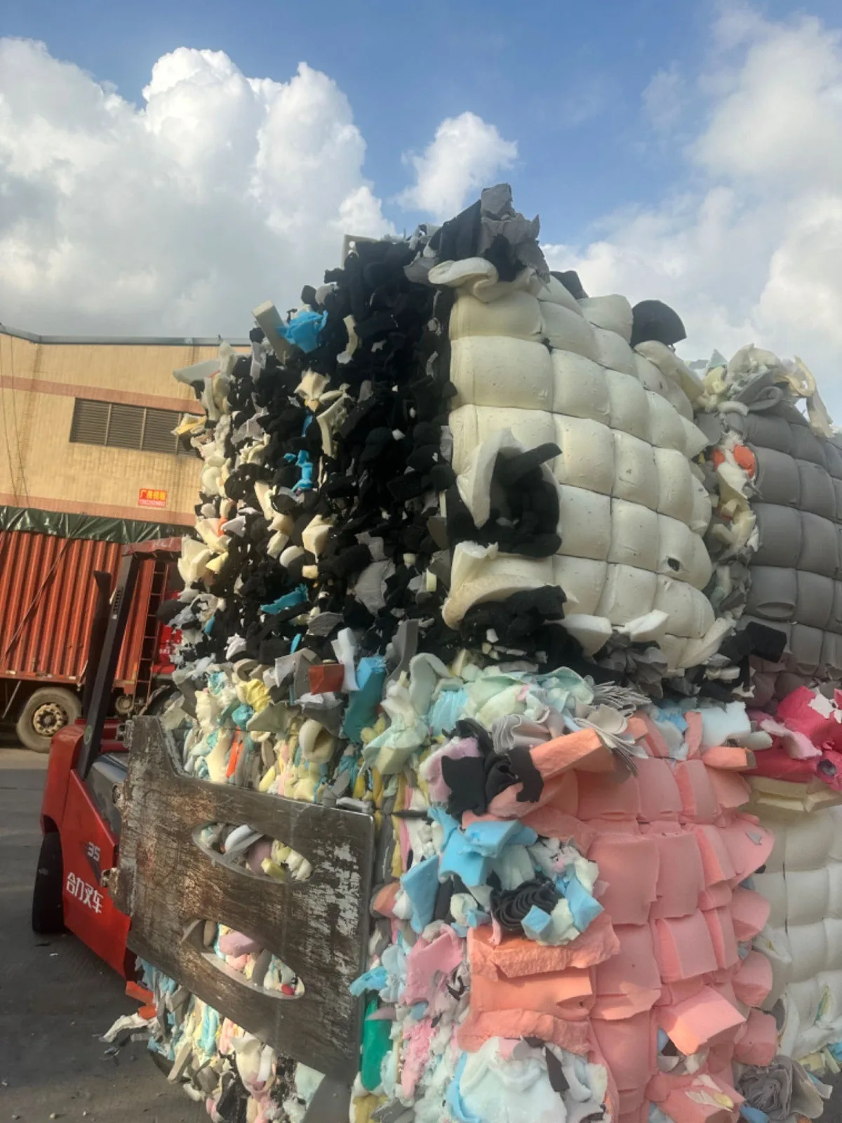 Pacas comprimidas de recortes de espuma siendo cargadas para envío